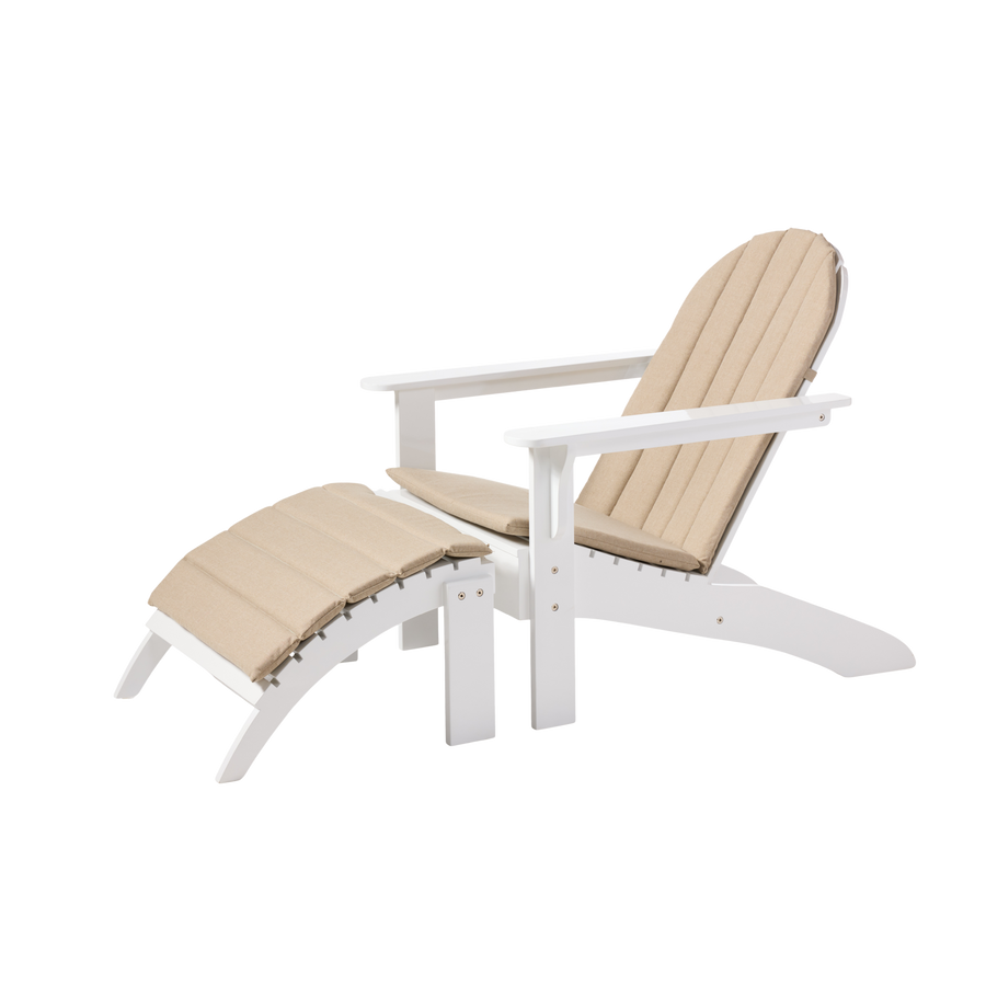 Set Adirondack Cinas — scaun și taburet din mahon vopsit alb, cu perne color nisip, în grădină liniștită.