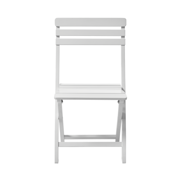 Scaun pliabil Clarish Cinas — scaun fără brațe din mahon pictat alb, pliat parțial pe un balcon mic.