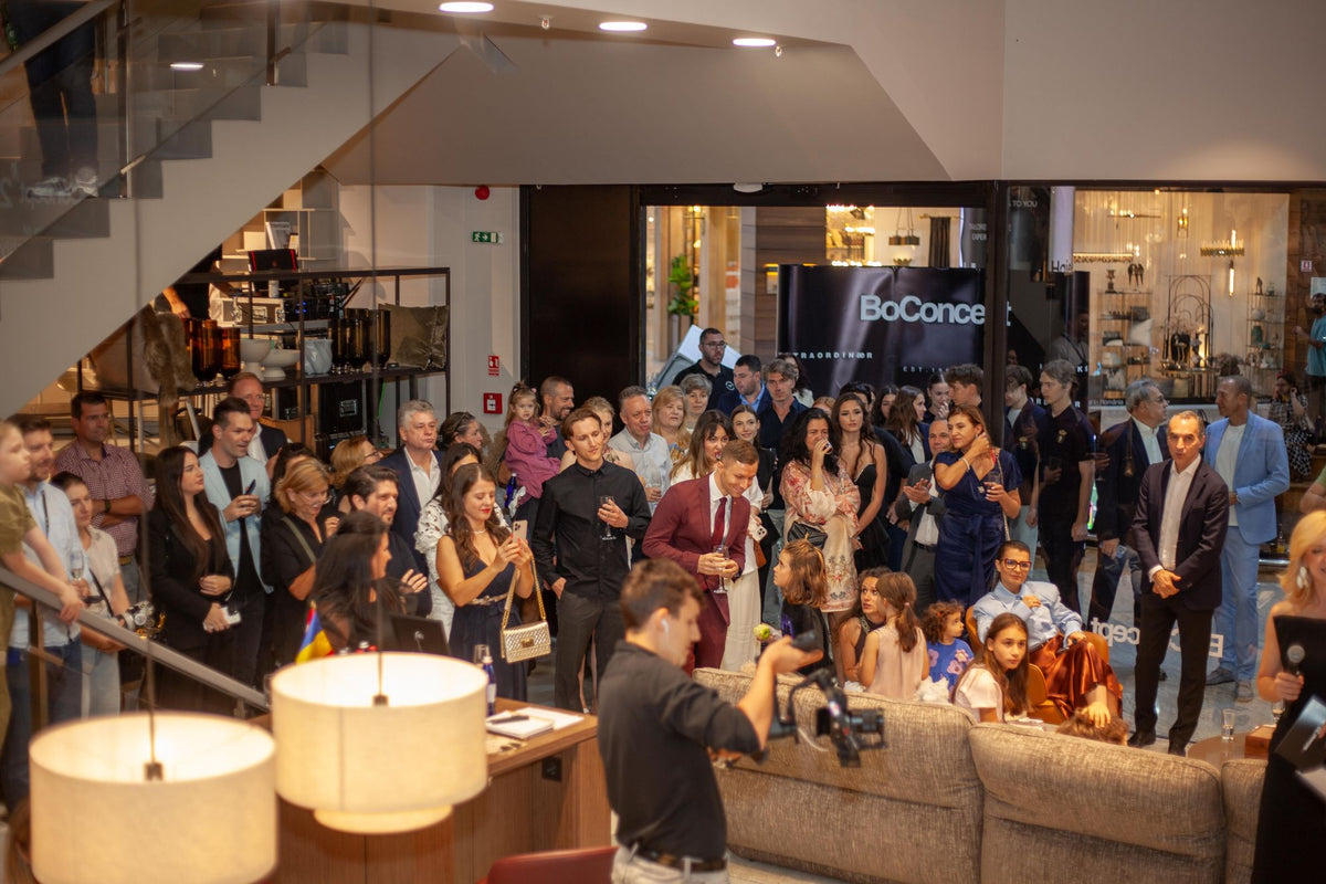 Guests fill the BoConcept showroom in Bucharest, on the stairs and around the sofas, at the 20th anniversary evening.