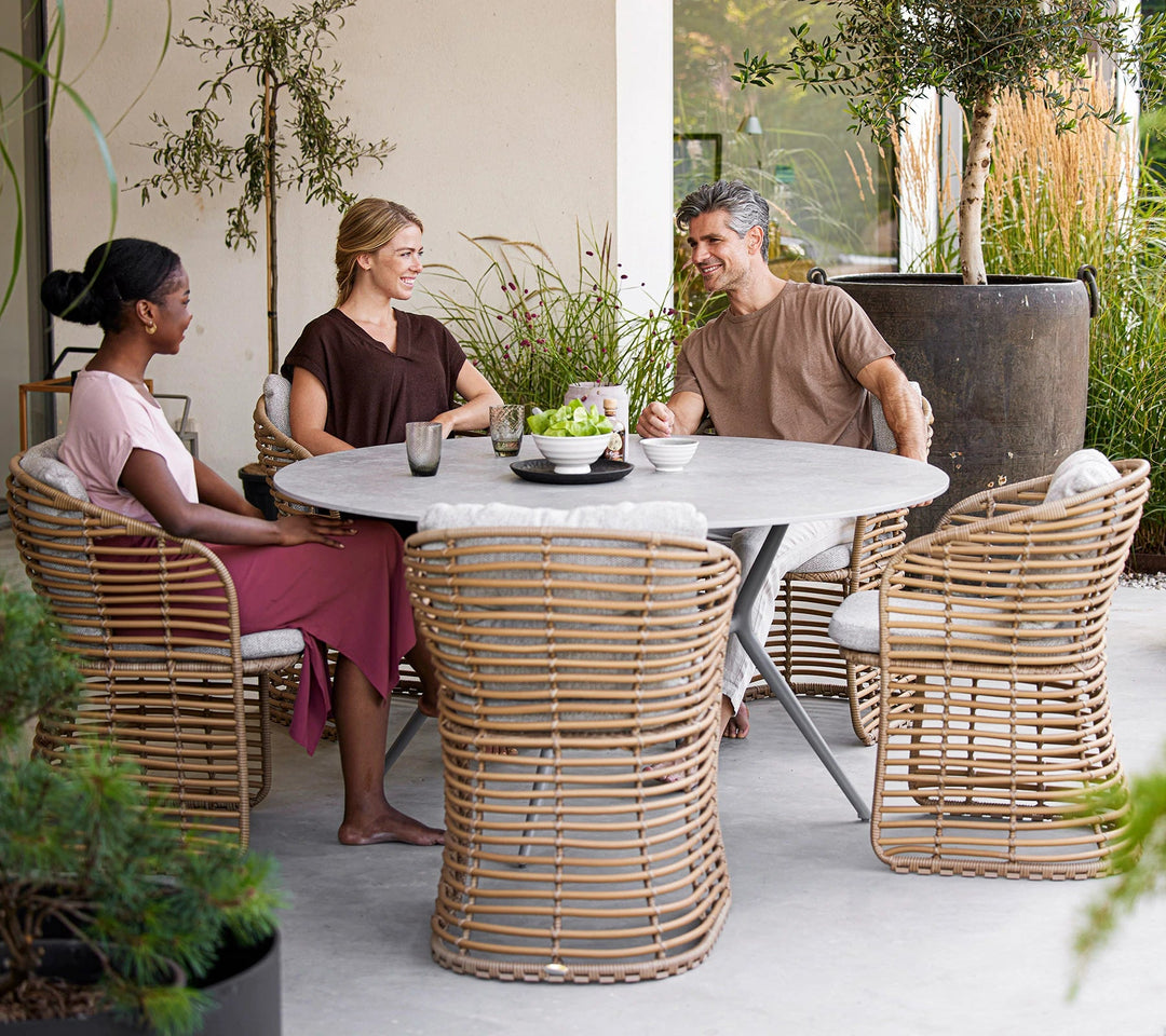 The Decorators: Masa de exterior rotunda Cane-line Joy Light Grey/Travertine look