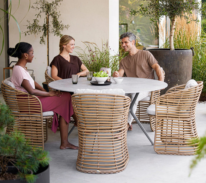 The Decorators: Masa de exterior rotunda Cane-line Joy Light Grey/Travertine look